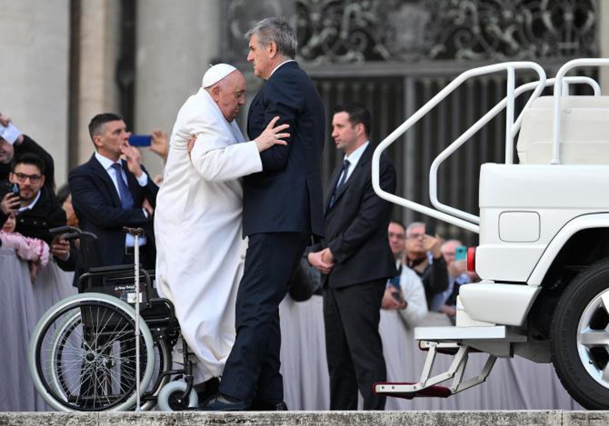 Un asistente trata de ayudar al Papa Francisco a subir al papamóvil tras la audiencia de este miércoles