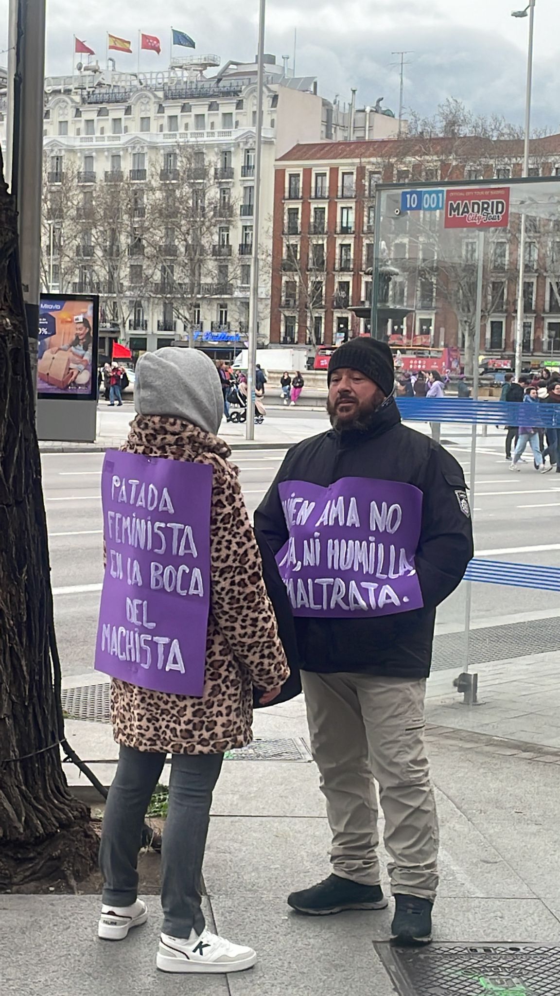 Un hombre y una mujer hablan antes del inicio de la manifestación de la Comisión 8M en Atocha