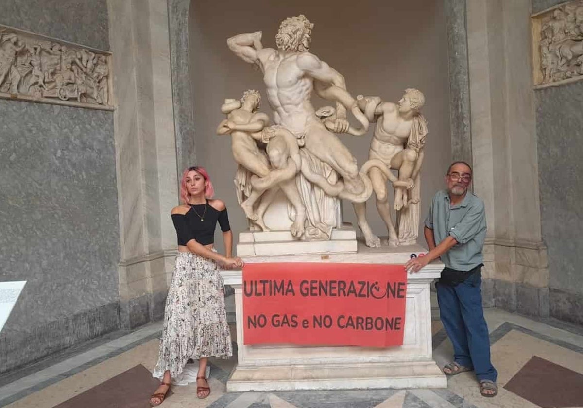 Los dos activistas con sus manos pegadas a la base del Laocoonte