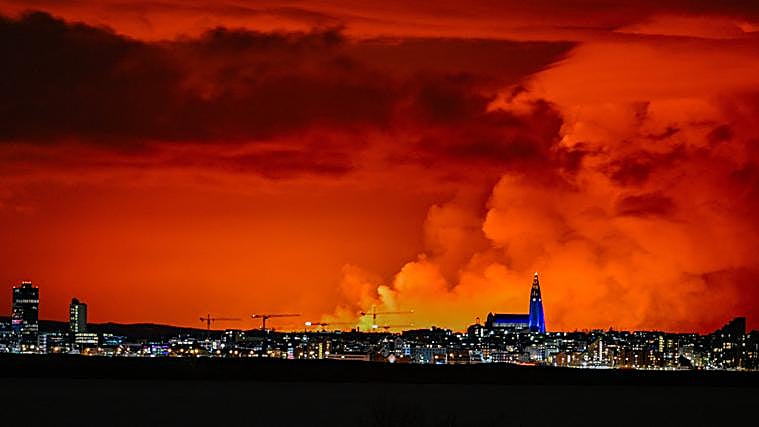 El horizonte de Reykjavik tiene como telón de fondo un cielo de color naranja debido a la lava fundida que fluye desde una fisura en la península de Reykjanes al norte de la ciudad evacuada de Grindavik