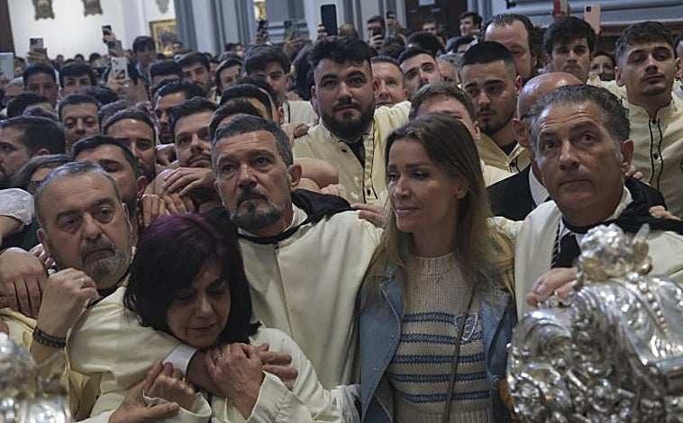 Imagen principal - En la parte superior, los miembros de la cofradía Lágrimas y Favores de Málaga, con el actor Antonio Banderas en el centro, esperan la decisión de los hermanos mayores, que finalmente han optado por la suspensión. Debajo, a la izquierda, unos nazarenos de La Amargura de Sevilla, se recogen después del anuncio de la suspensión de la procesión por la lluvia. A la derecha, un costalero de la procesión de Nuestro Padre Jesús del Amor de Madrid, conocida como La Borriquita