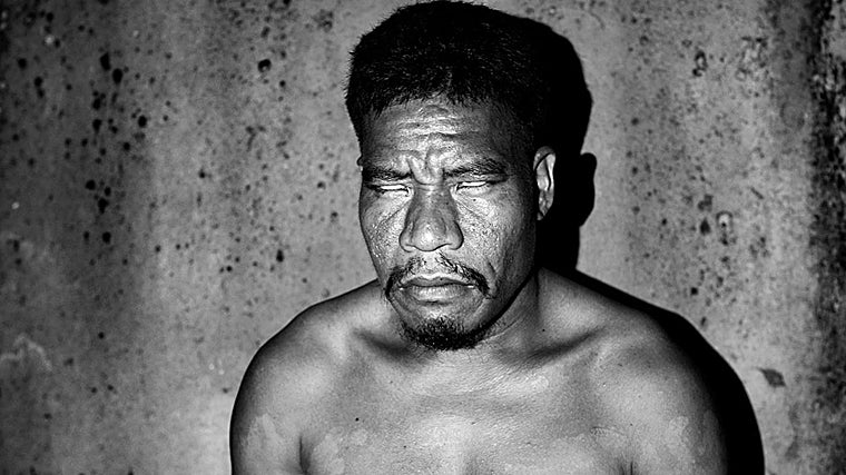 Eric, que es daltónico, reacciona a la luz mientras posa para un retrato iluminado con una linterna. En Pingelap solo hay electricidad solar, por eso por la noche todos se desplazan con la ayuda de linternas