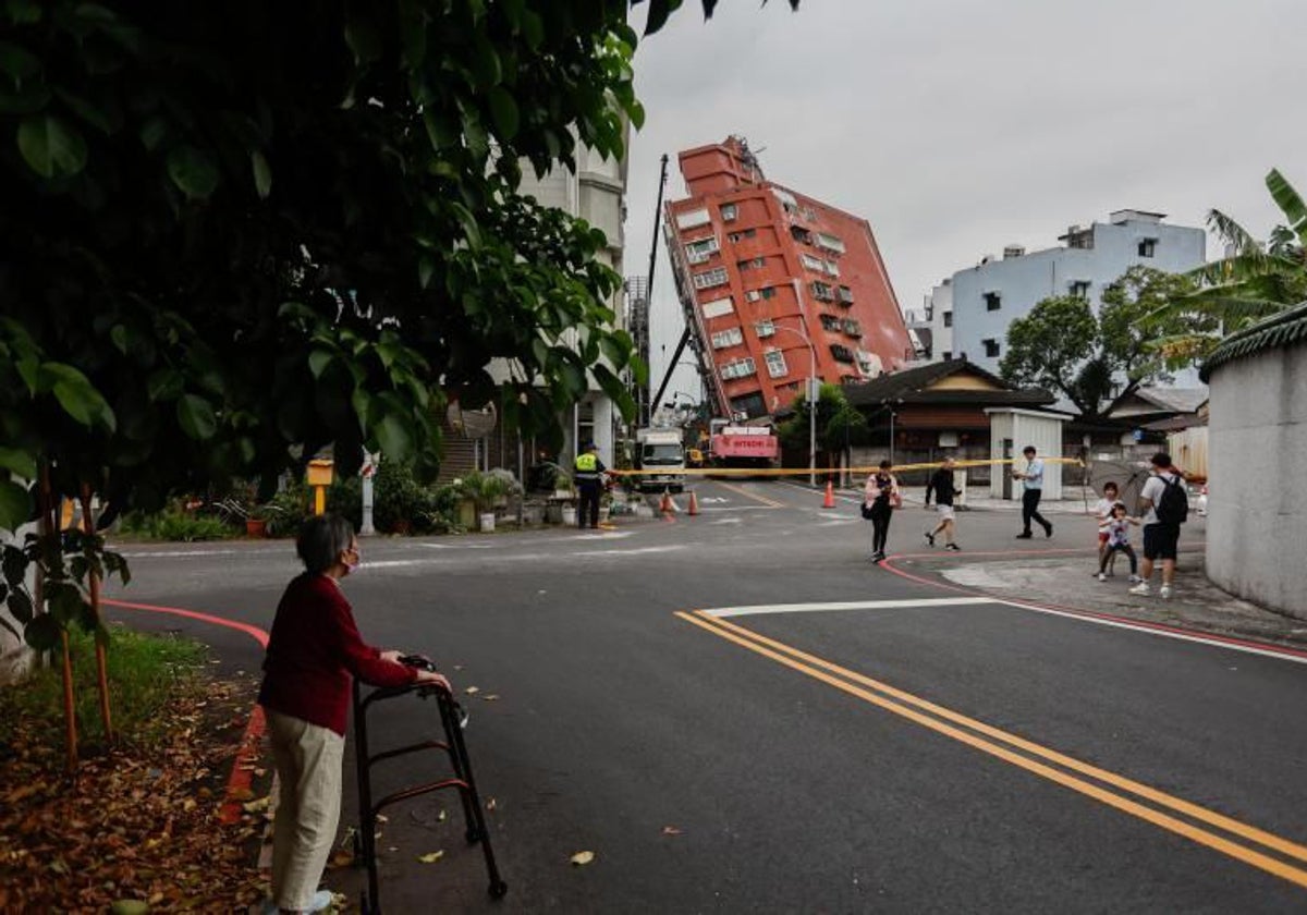 La gente camina cerca del edificio residencial Urano parcialmente derrumbado, tras el terremoto del 3 de abril en Hualien, Taiwán