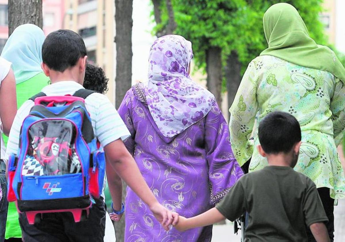 Mujeres con velo transitan por una calle