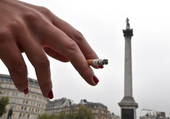 Una mujer fuma en Trafagal Square, en Londres