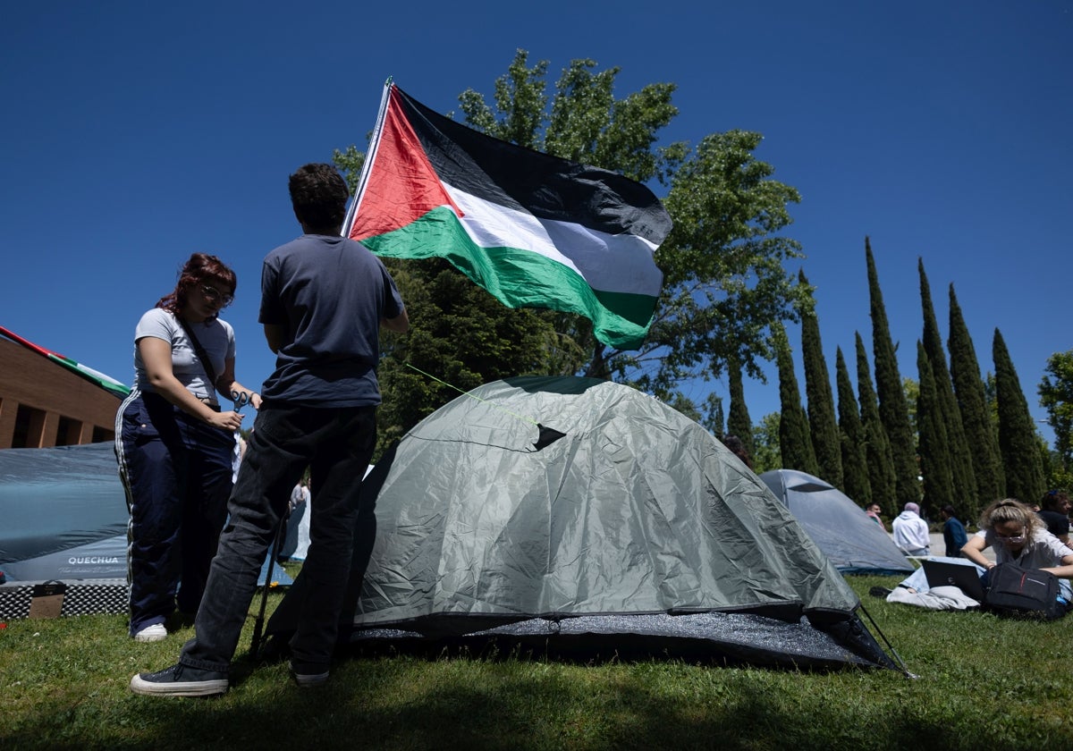 Dos estudiantes con una bandera de Palestina durante una acampada para mostrar su apoyo al pueblo palestino en la Universidad Complutense