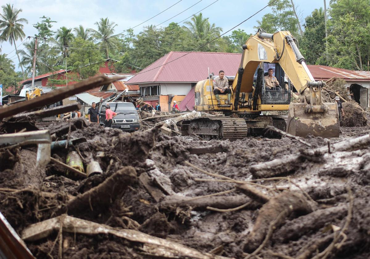 Maquinaria pesada limpia el barro y los escombros de la escena tras las mortales inundaciones