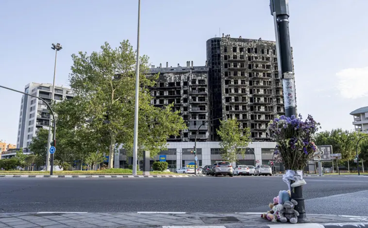 Imagen principal - Un pequeño memorial con peluches y flores, al otro lado de la rotonda, recuerda a los fallecidos en el incendio, entre los que se encontraban niños. Una imagen más cercana permite reconocer los daños causados. En la tercera imagen, José Javier señala con el dedo donde se encontraba su piso.