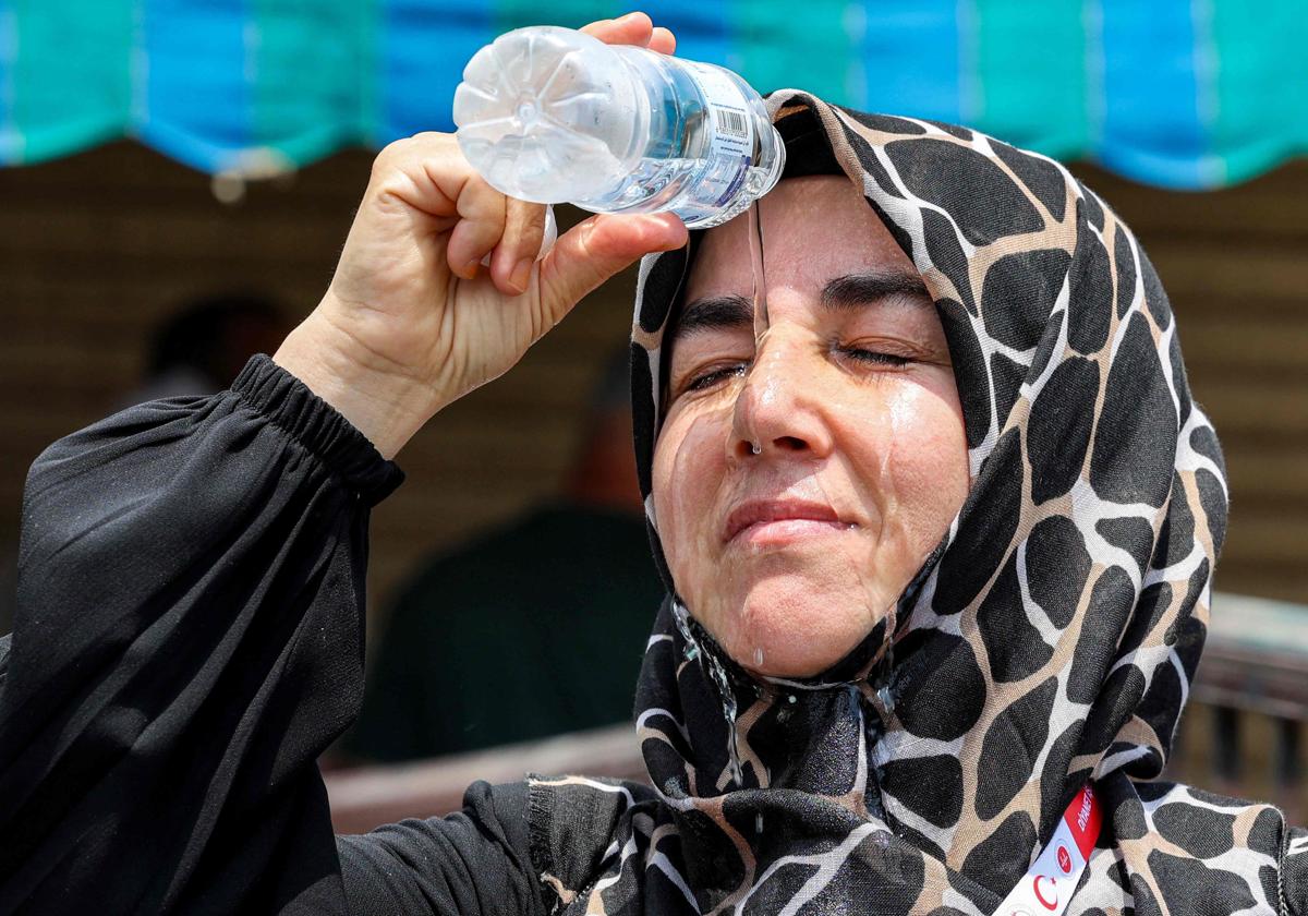 Una musulmana turca se vierte agua sobre la cara