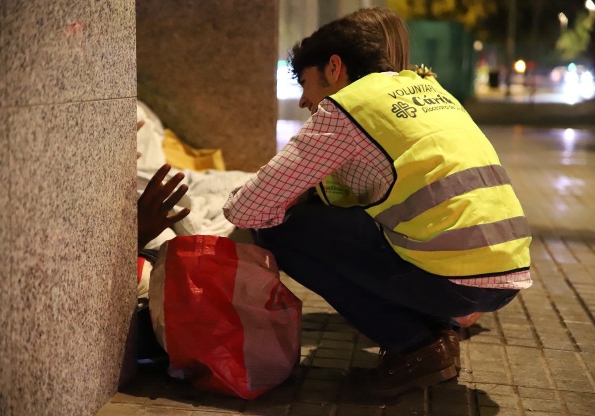 Voluntarios de Cáritas ayudando a una persona sin hogar