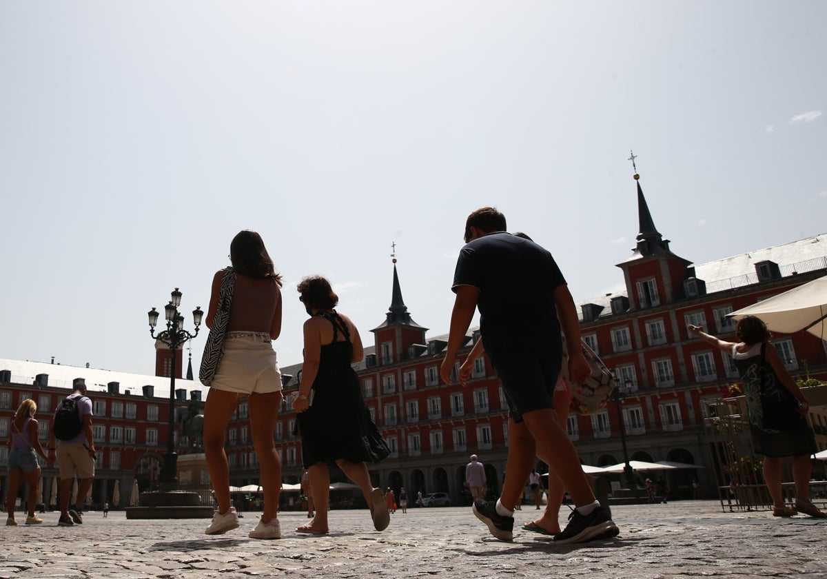 Un grupo de transeúntes disfrutan de la Plaza Mayor de Madrid