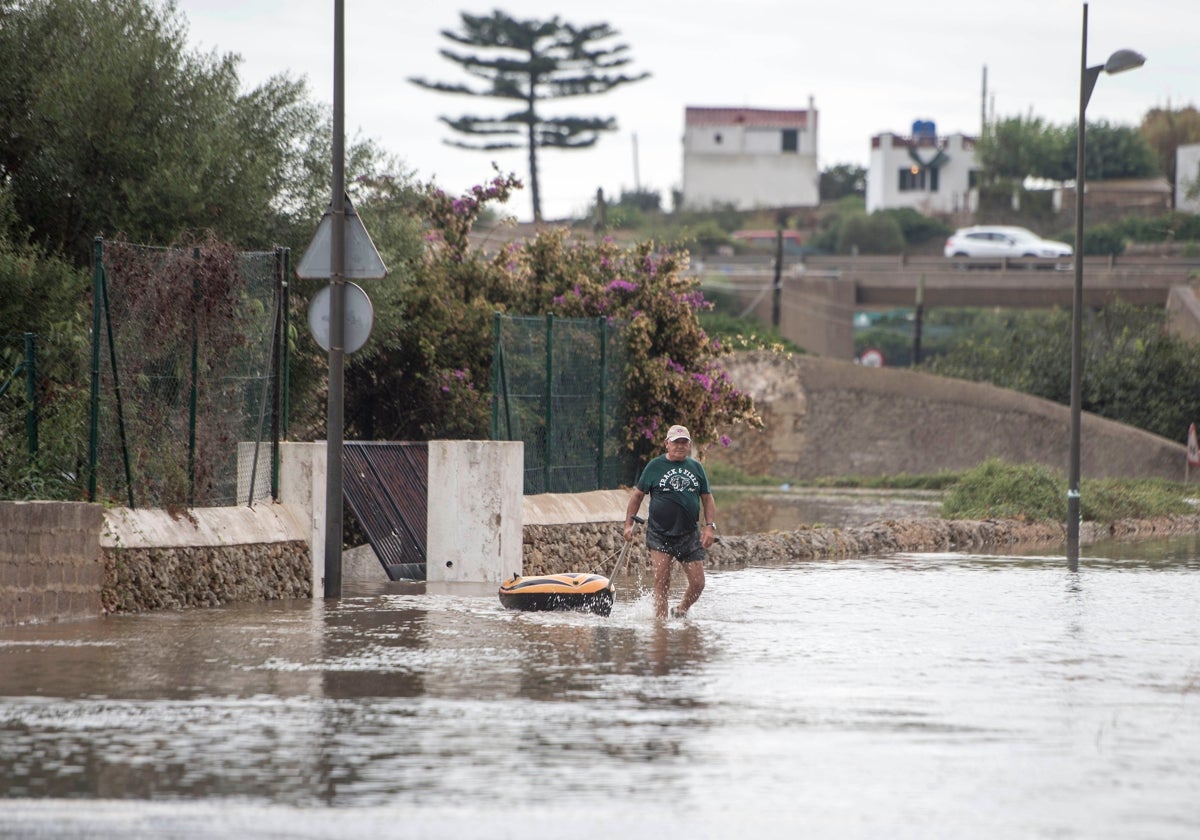 Un hombre atraviesa una zona inundada a causa del reciente paso de una DANA, este jueves en Alaior, Menorca