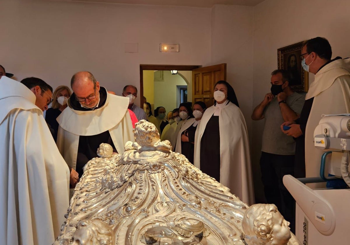 Los carmelitas descalzos Miguel Ángel González y Marco Chiesa abren el sepulcro de plata que conserva el cuerpo de la santa