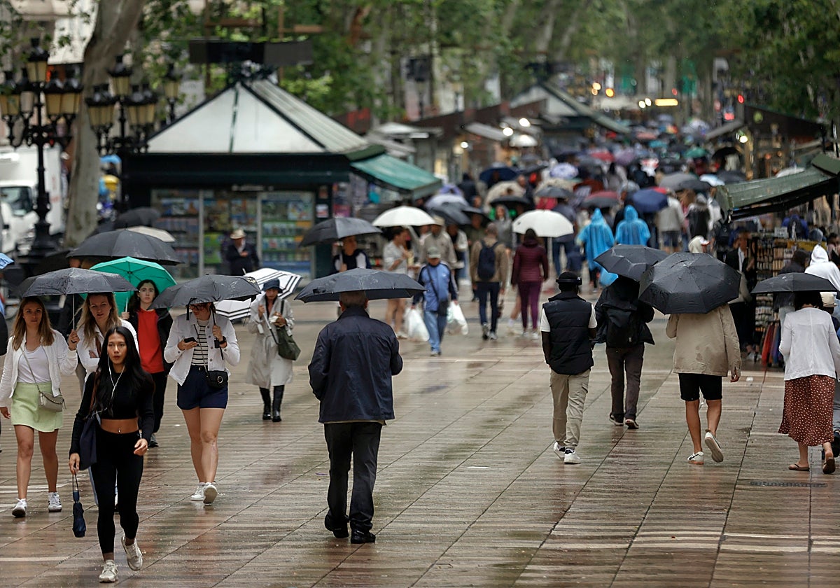 Imagen de personas bajo la lluvia en Cataluña