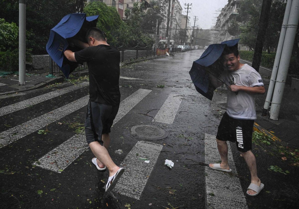 Peatones luchan con sus paraguas bajo los fuertes vientos y la lluvia del paso del tifón Bebinca