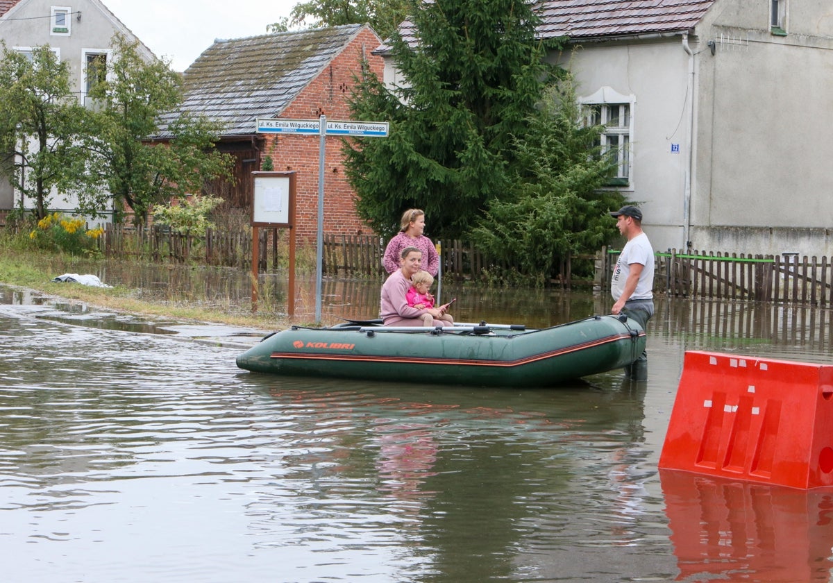 Personas viajado en un barco por una calle inundada cerca del río Kwisa en Osiecznica, Polonia