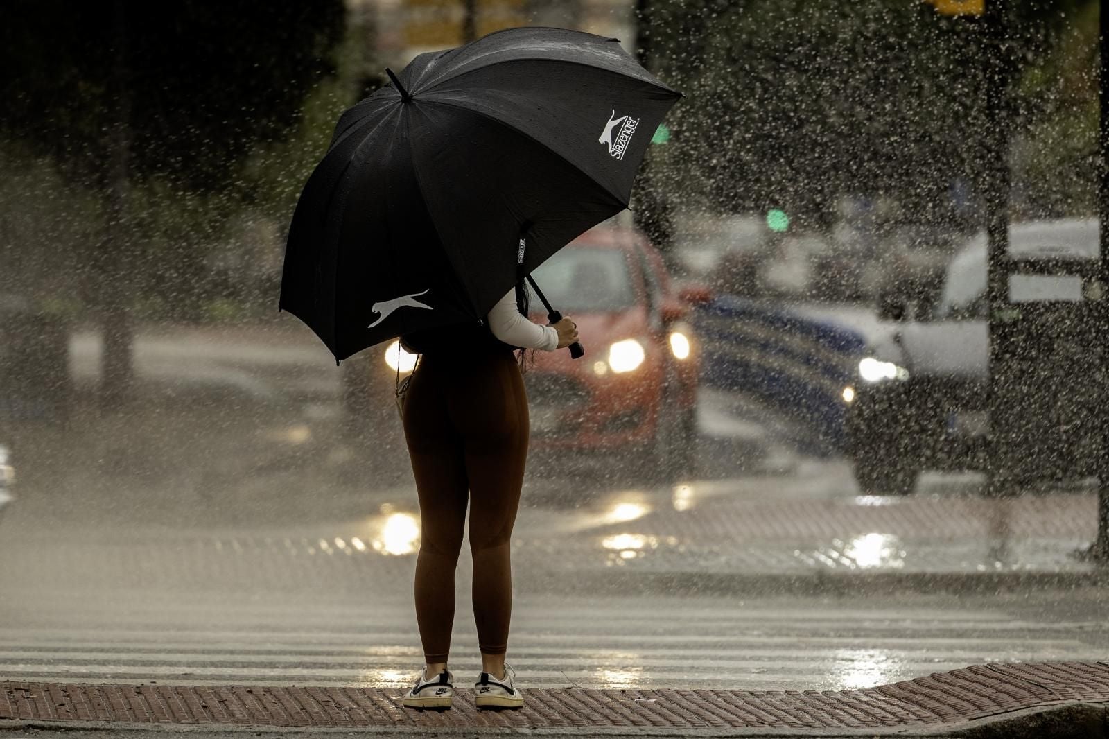 Una mujer se resguarda de la lluvia bajo un paraguas este martes en Málaga