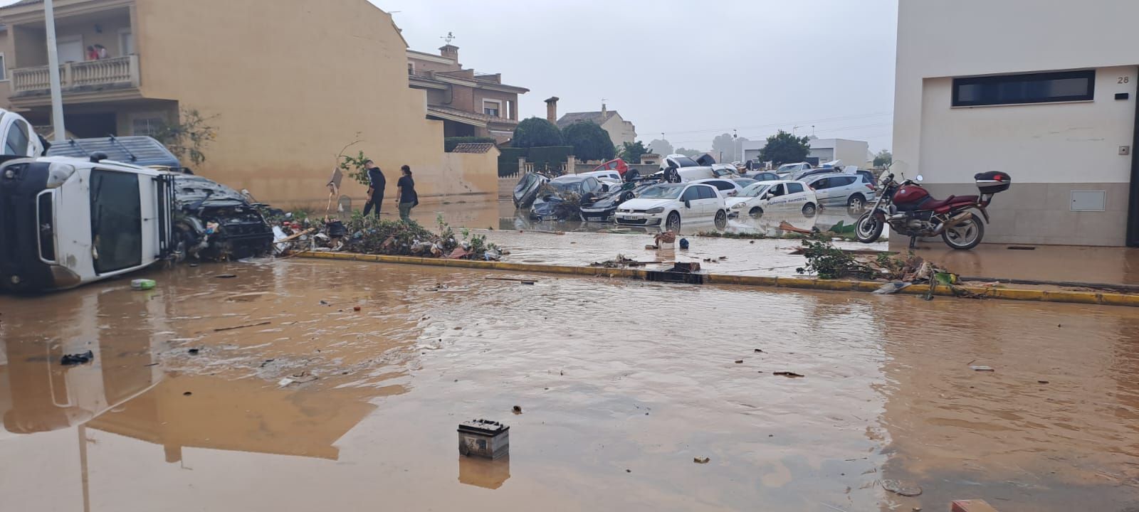 Una imagen de varios coches aparcados que han sobrevivido en la calle, con un camión en el suelo
