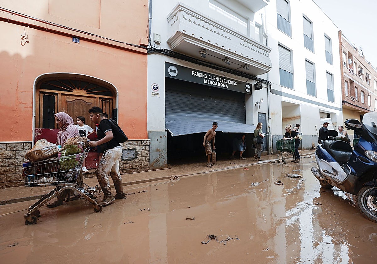 Varias personas salen de un mercadona tras saquearlo en Valencia