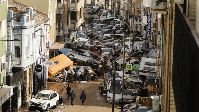 Vehículos amontonados en una calle tras las intensas lluvias de la fuerte en Picaña (Valencia)