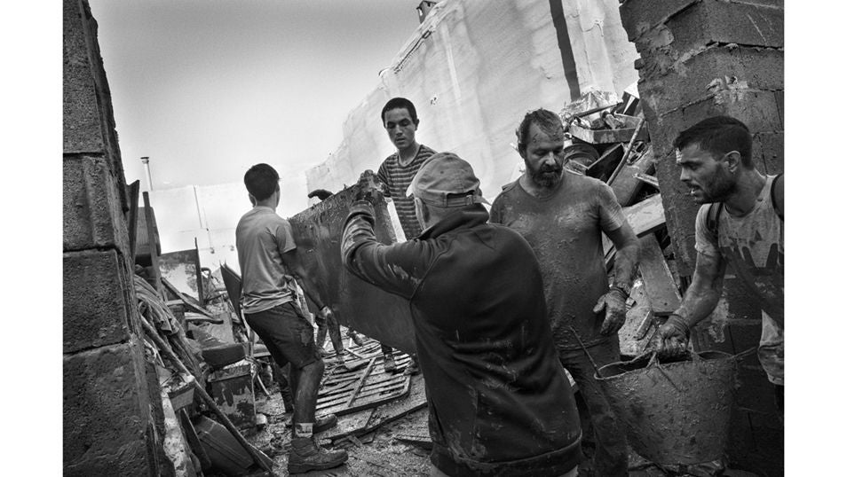 Un grupo de voluntarios de afanan en apartar escombros de las calles de Paiporta tras el paso de la DANA