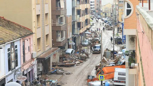 Image after - Cars stacked on Avenida Gómez Ferrer (Sedaví) before being removed by volunteers, neighbors and heavy machinery