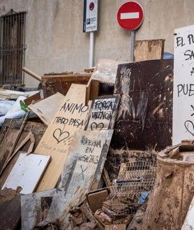 Imagen secundaria 2 - Decenas de policías voluntarias, sobre todo catalanes y vascos, se vuelcan para ayudar a los afectados. Arriba, liberando una calle de Catarroja. Abajo a la izquierda, retirando un coche. A la derecha, mensajes de agradecimiento en restos apilados 