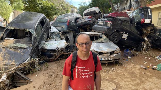 Imagen antes - Moisés Pitarch, el 2 de noviembre en su calle del Barrio Orba o Parque Alcosa, cuando estaba cortada por una montaña de coches arrastrados por la riada, y una semana después, tras la retirada de los vehículos y del fango.