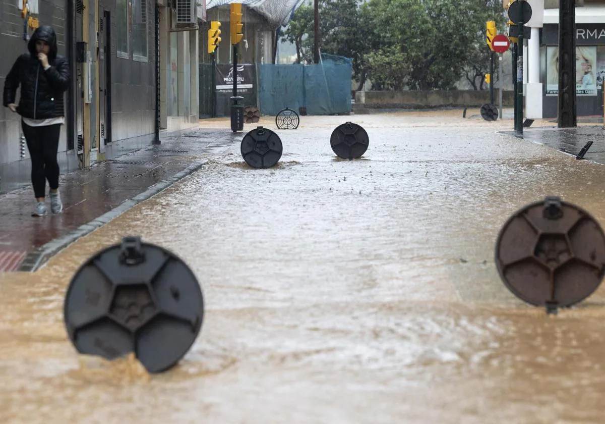 Alcantarillas abiertas en una calle de la barriada de Campanillas por la DANA en Málaga