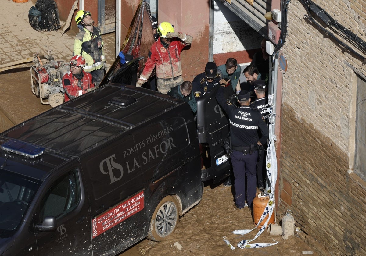 Guardias civiles y policías locales retiran un cadáver de un garaje en el barrio valenciano de La Torre