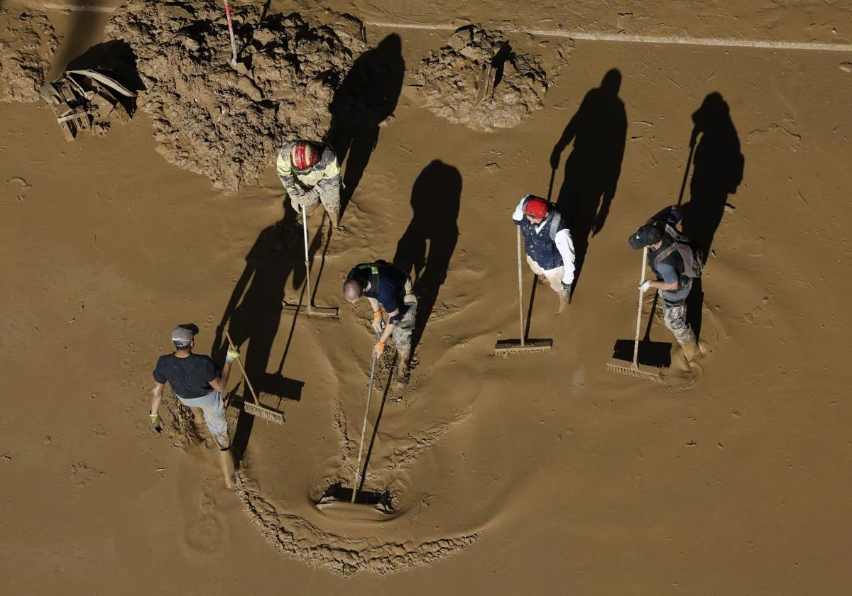 Voluntarios limpian una calle de Paiporta, Valencia