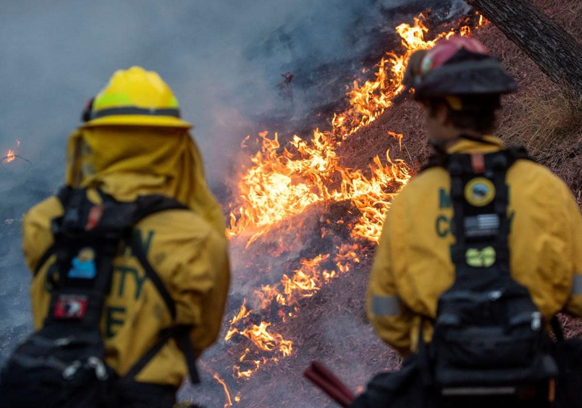 Varios bomberos intentan apagar un foco de una casa incendiada