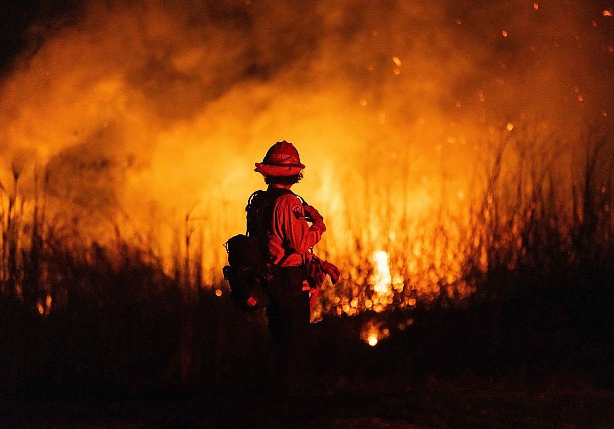 Un bombero controla la propagación del incendio de un automóvil en Oxnard, al noroeste de Los Ángeles