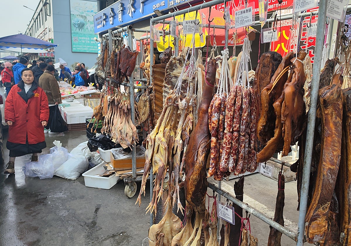 Una tendera vende carnes curadas de varios animales en el Nuevo Mercado de Huanan