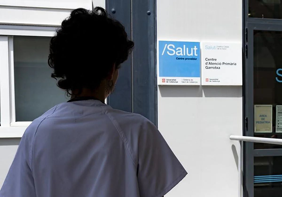 Una doctora frente al rótulo en catalán de un centro de atención primaria de la red pública