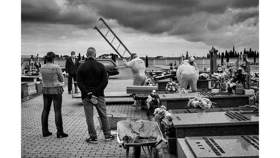 Una familia asiste al entierro de su familiar, víctima de COVID-19, en un cementerio de la provincia de Ciudad Real.Las estrictas medidas de seguridad decretadas por el gobierno de España para prevenir la propagación del virus impiden que las familias se despidan de sus seres queridos como desearían. Solo tres miembros de la familia por fallecido pueden estar presentes en el funeral.Se estima que la pandemia ha causado más de 70.000 muertes en España, de las cuales más de 50.000 han sido confirmadas mediante pruebas PCR. Según un estudio de seroprevalencia, el 5% de la población española había sido infectada por el virus hasta junio.