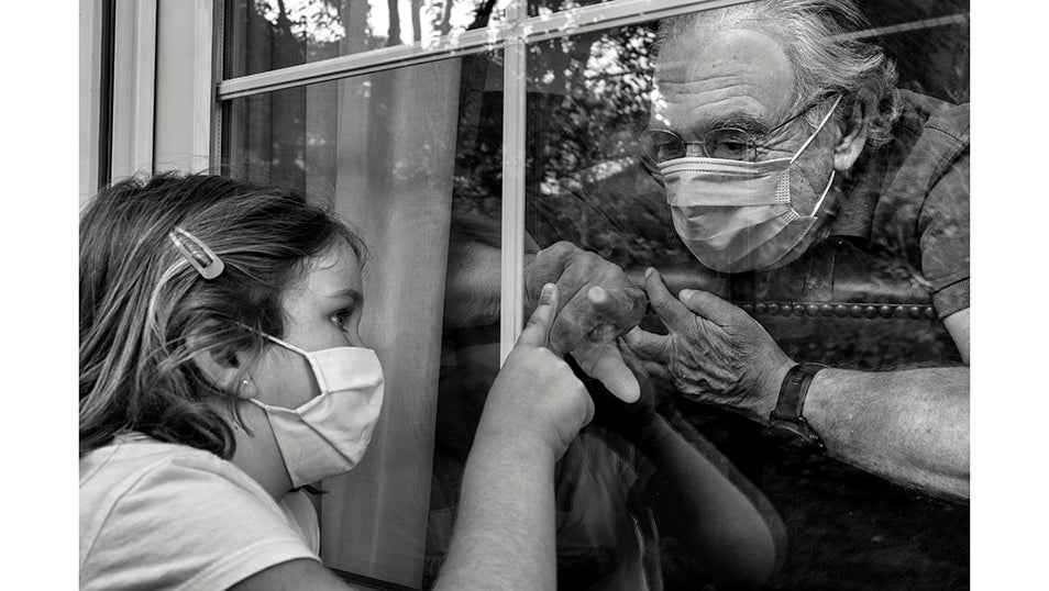 Lucía juega con su abuelo Antonio separado por un cristal por miedo al contagio de COVID-19.El 14 de marzo, cuando había alrededor de 6.000 casos y 200 muertes en España, el gobierno español declaró el estado de alarma en todo el país con el fin de frenar la emergencia sanitaria causada por la pandemia de COVID-19. A mediados de mayo, España era el quinto país en cuanto a casos confirmados (232.037 positivos), por detrás de Estados Unidos, Rusia, Brasil y el Reino Unido, y también el quinto país en cuanto al número de muertes, por detrás de Estados Unidos, el Reino Unido, Italia y Francia. Se estima que la pandemia ha causado más de 70.000 muertes en España, de las cuales más de 50.000 han sido confirmadas mediante prueba PCR. La gran mayoría de los fallecidos eran personas mayores de 65 años. Según un estudio de seroprevalencia, hasta junio, el 5% de la población española había sido infectada por el virus.