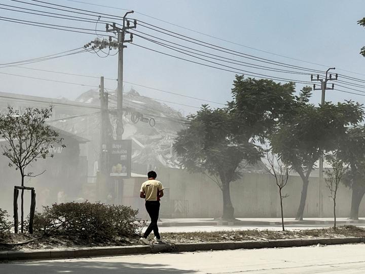 Hombre caminando cerca de una vivienda derruida 