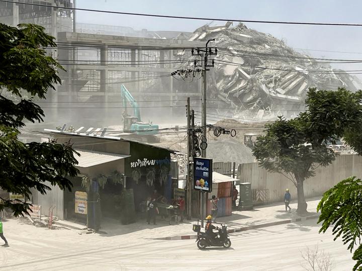 Una persona en moto a las afueras de un edificio destruido por el terremoto