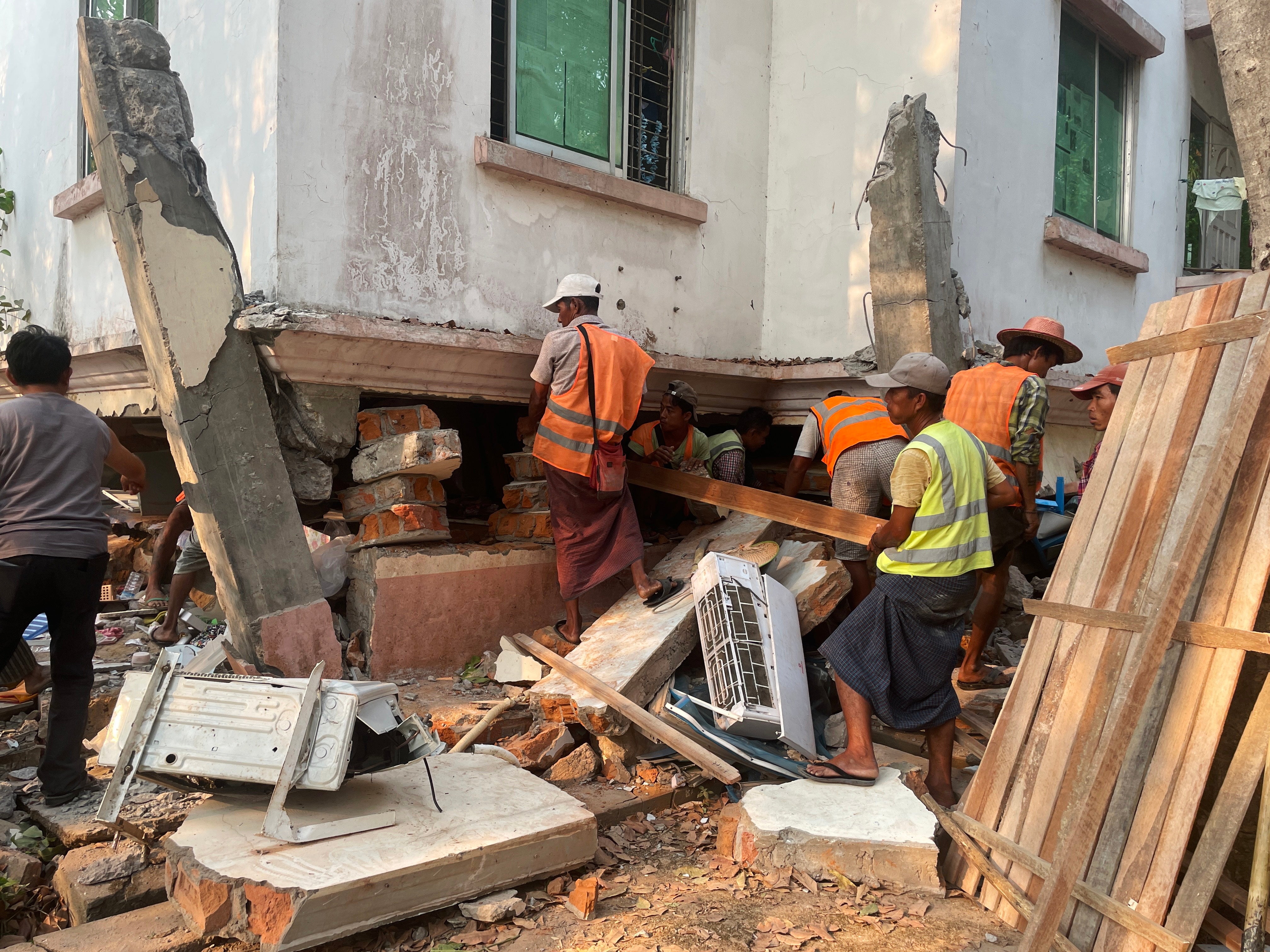 Los equipos de rescate buscan supervivientes en los edificios de viviendas del personal gubernamental dañados tras un terremoto en Naypyidaw.
