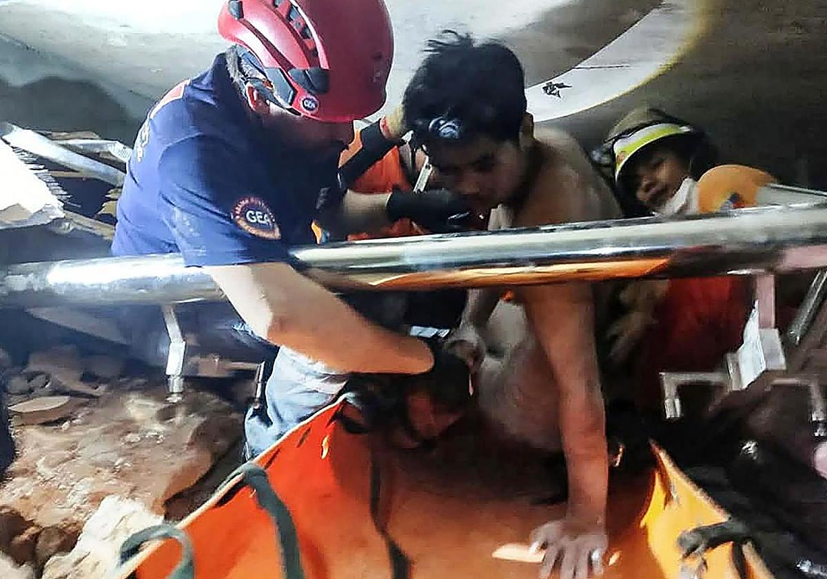 Rescatistas de Myanmar y Turquía sacando a un hombre vivo de entre los escombros de un hotel en la capital, Naypyidaw