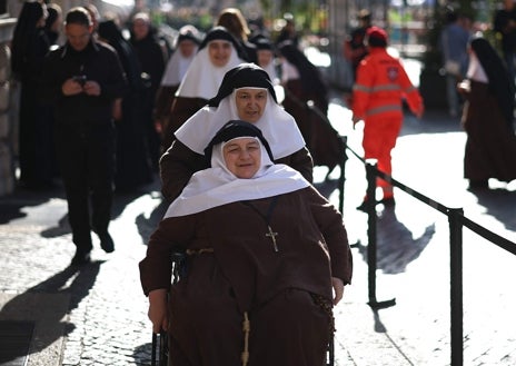 Imagen secundaria 1 - Banderas, religiosas y grupos de jóvenes se han desplazado hasta Via della Conciliazione