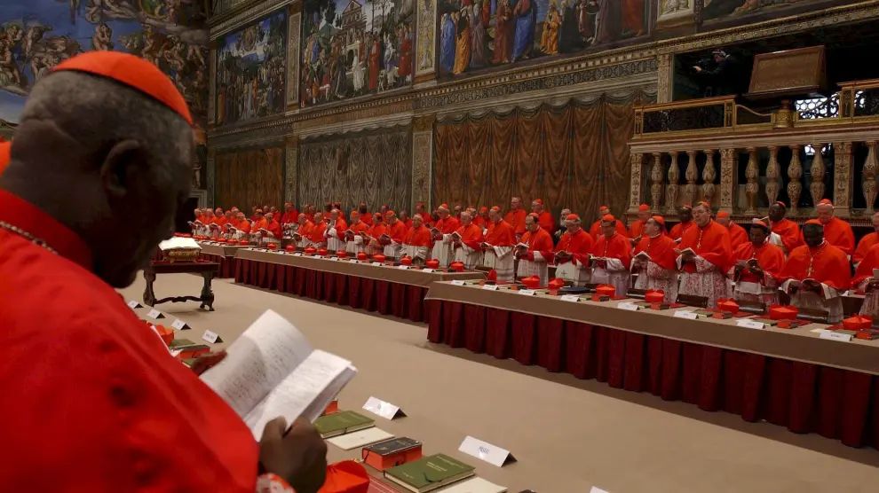 Cardenales leen el reglamento del cónclave en una imagen de archivo