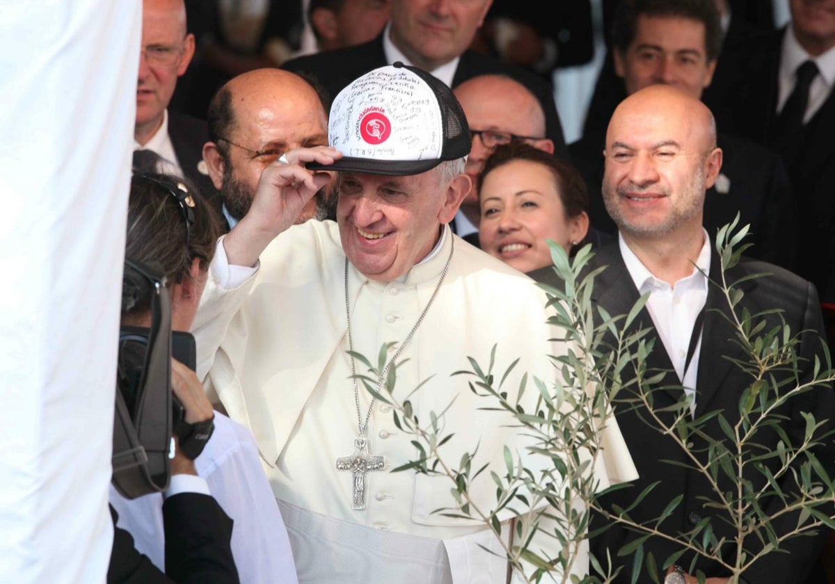 Imagen de archivo tomada en 2015 del Papa Francisco mientras se pone una gorra llena de mensajes de agradecimiento que le regalaron durante una misa celebrada en Ñu Guazu, una base militar en Asunción (Paraguay)