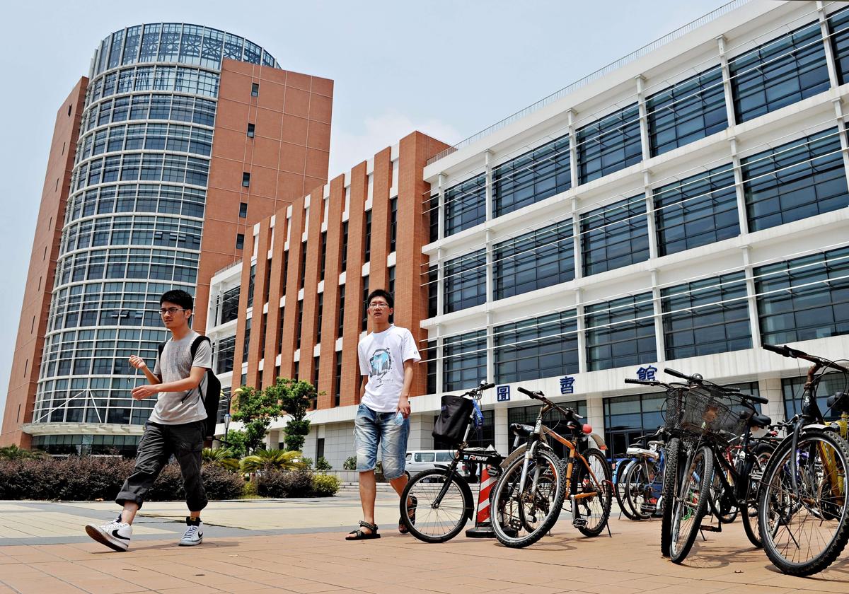 Unos estudiantes universitarios chinos salen de una biblioteca en Shang