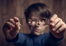 Un niño muestra sus gafas