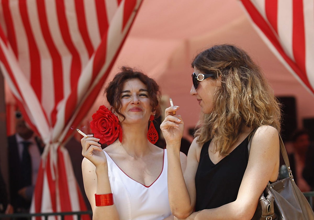 Dos mujeres fuman en la Feria de Sevilla