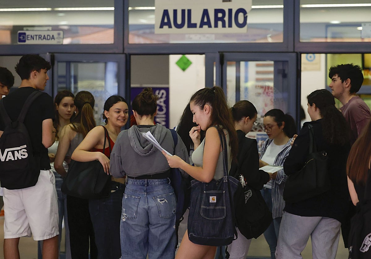 Varios estudiantes repasan sus apuntes mientras aguardan la apertura de las aulas antes del inicio de la PAU en la Universidad Complutense de Madrid.