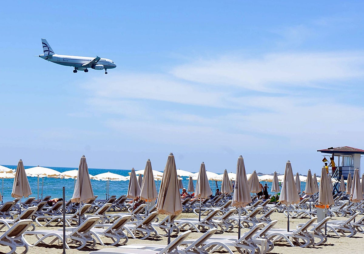 Imagen de archivo de un avión sobrevolando una playa