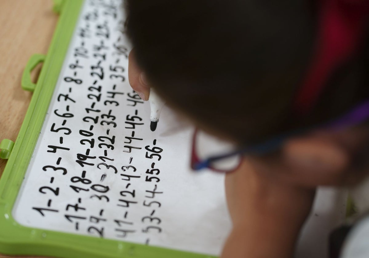 Una alumna de Primaria escribiendo los números